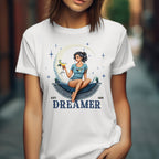 Person wearing a white t-shirt with a graphic design of a woman holding a cocktail and the word 'Dreamer'.