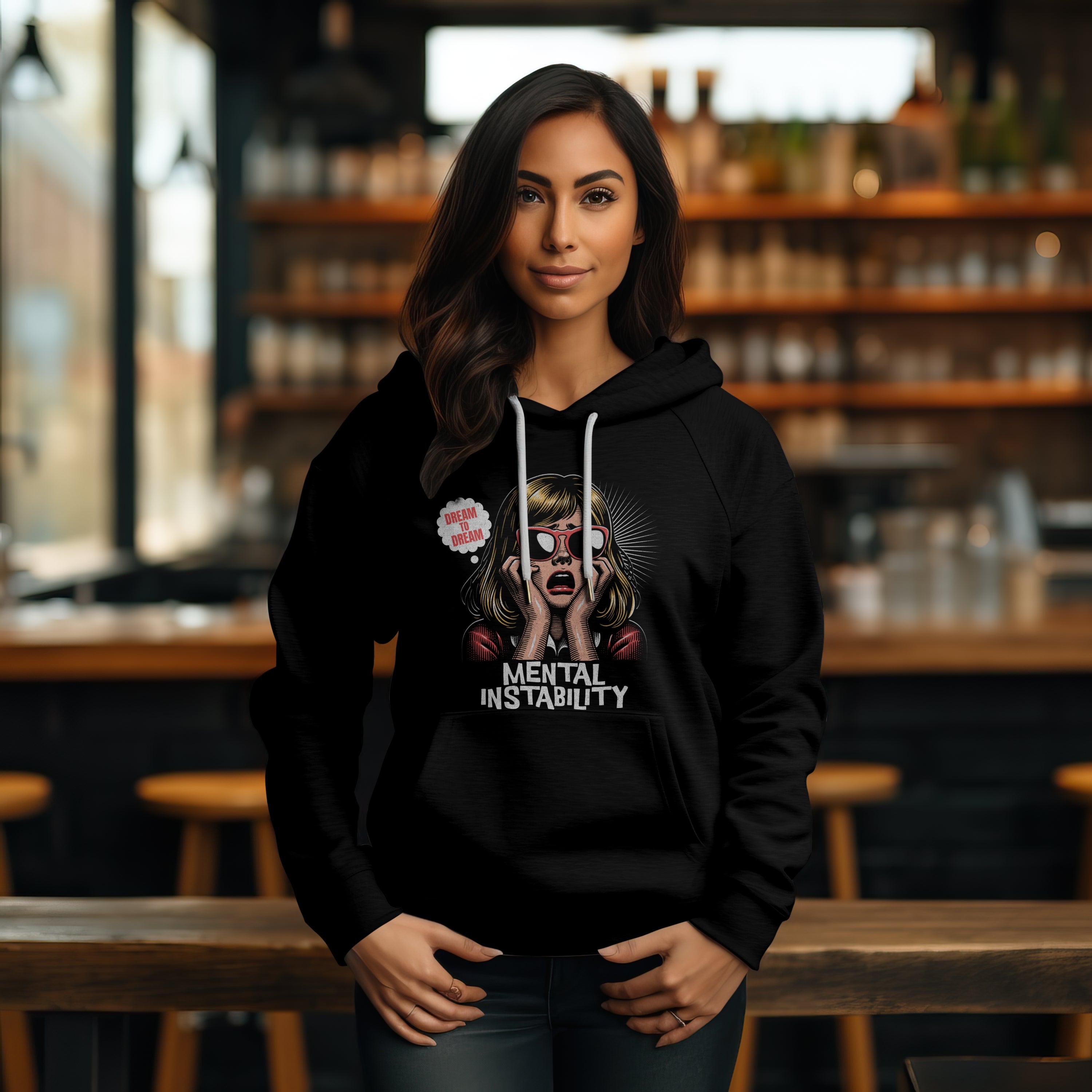 Woman wearing a black hoodie with graphic design in a bar setting