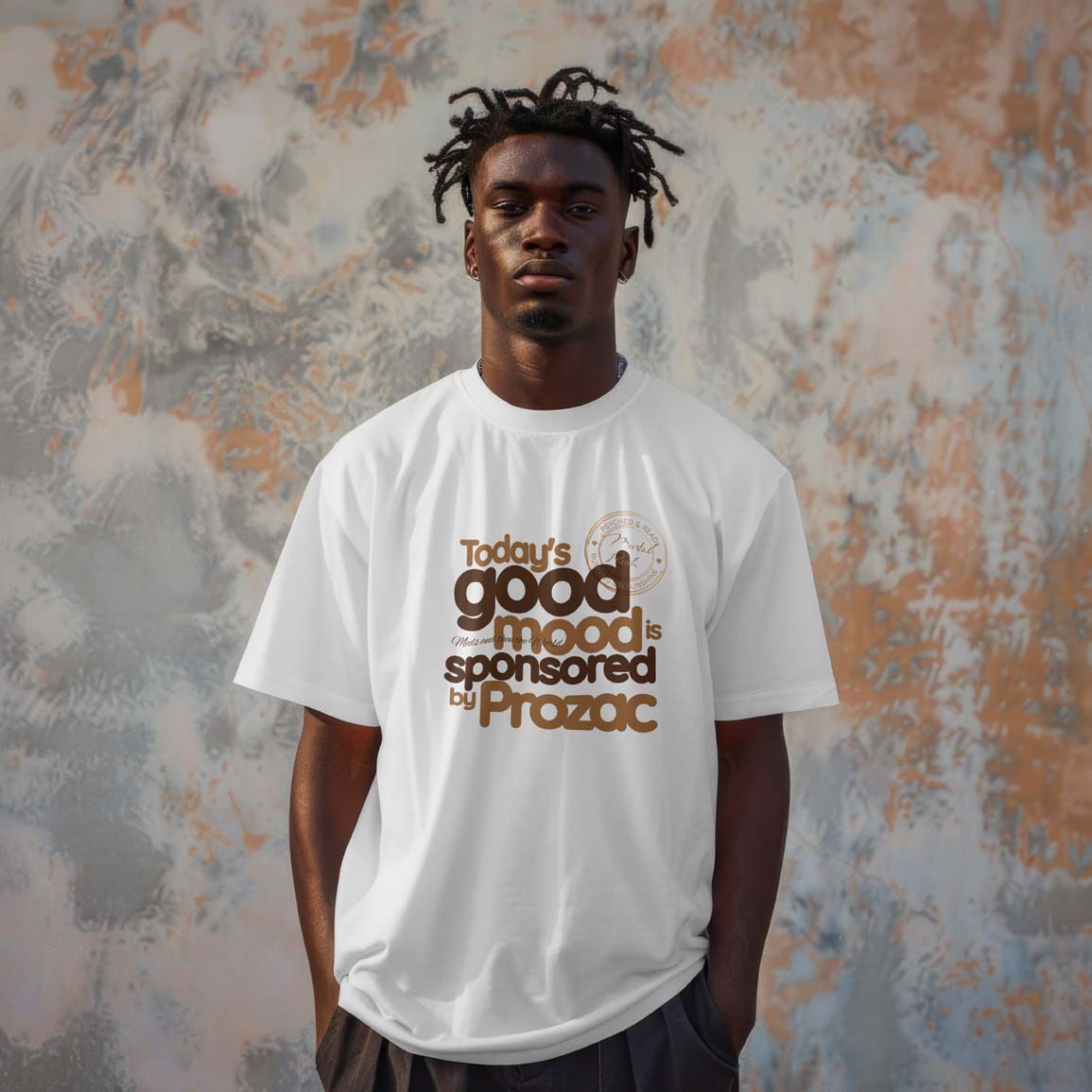 Person wearing a white t-shirt with text in front of a textured wall