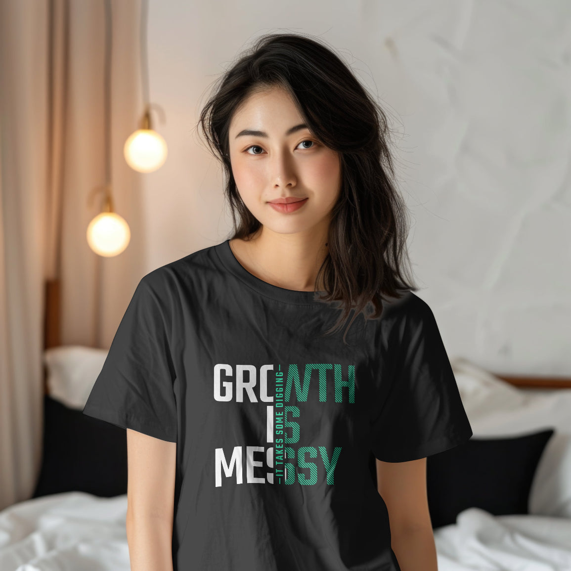 Woman wearing a black t-shirt with 'Growth is Messy' text in a bedroom setting