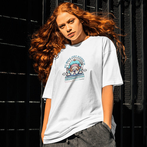 Person wearing a white t-shirt with a graphic design against a black background