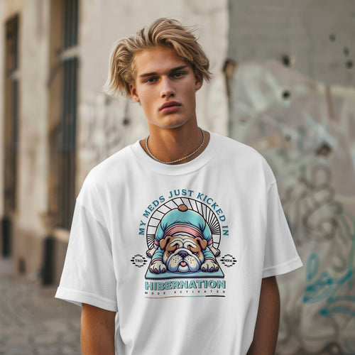Person wearing a white t-shirt with a graphic design and text, standing against an urban background.