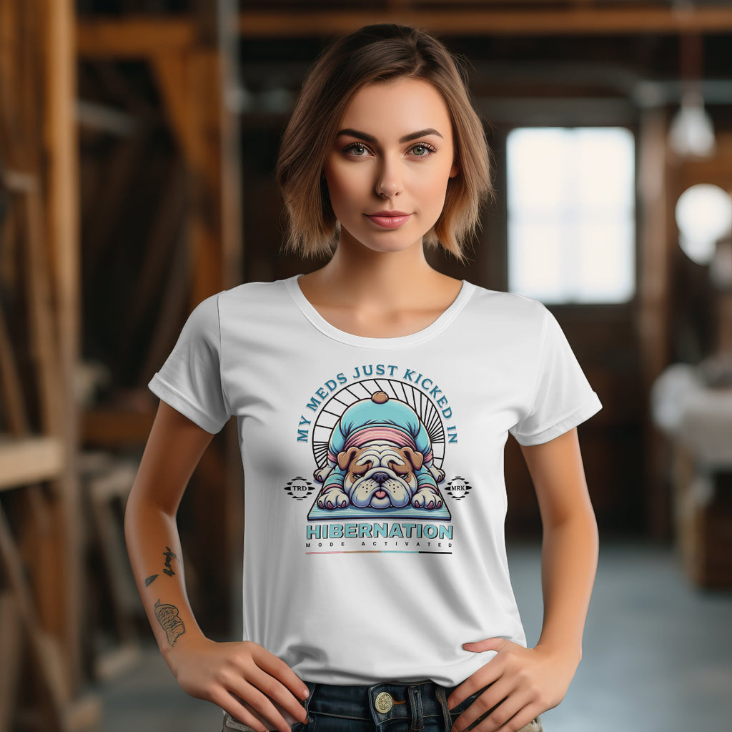 Woman wearing a white t-shirt with a graphic design of a dog in hibernation, text 'My meds just kicked in hibernation', in an indoor setting.