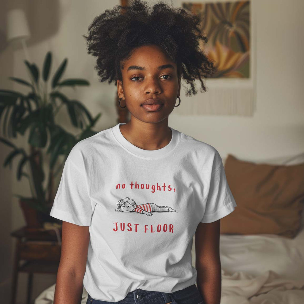 Young girl wearing a white t-shirt with text and graphic design in a room with plants and furniture.