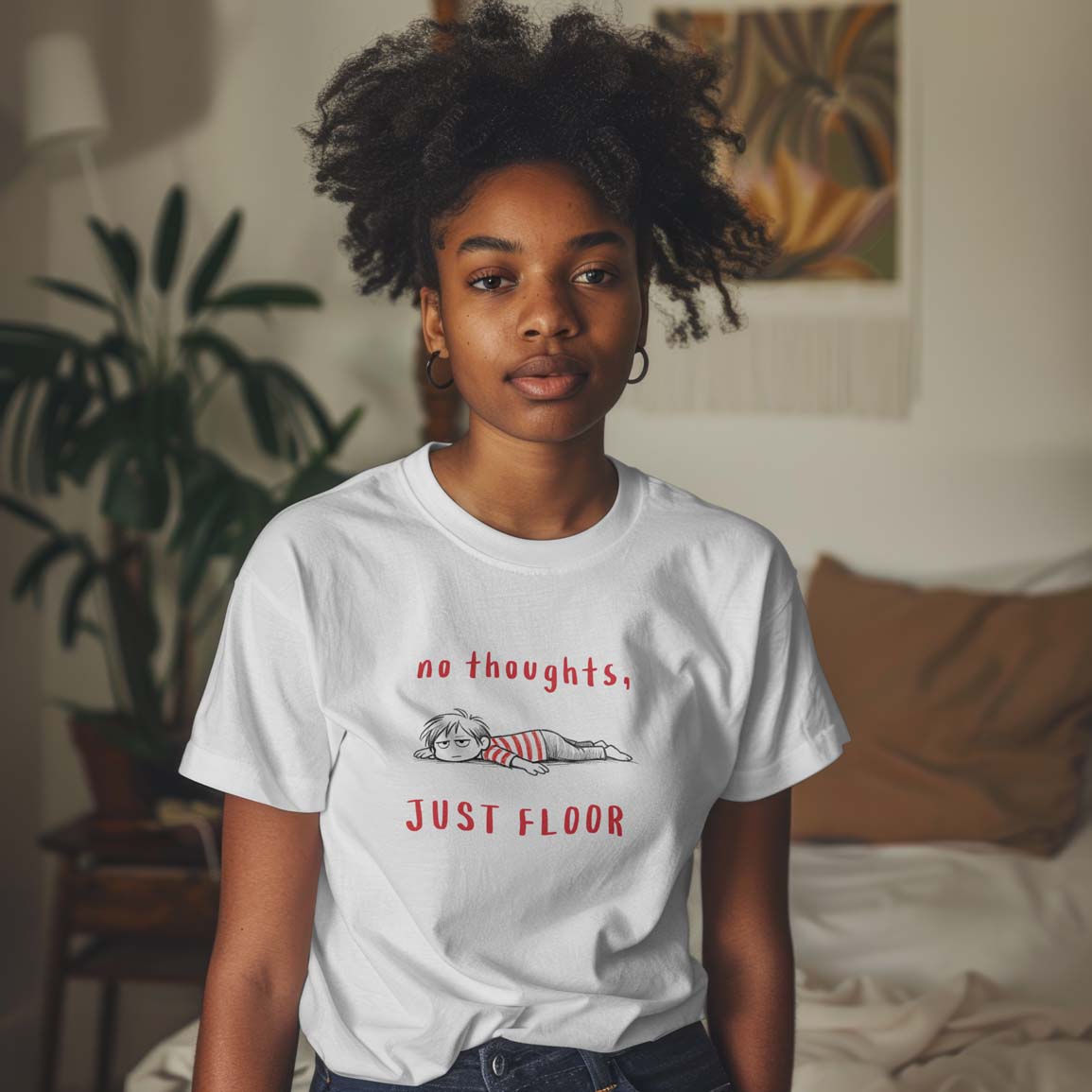 Young girl wearing a white t-shirt with text and graphic design in a room with plants and furniture.
