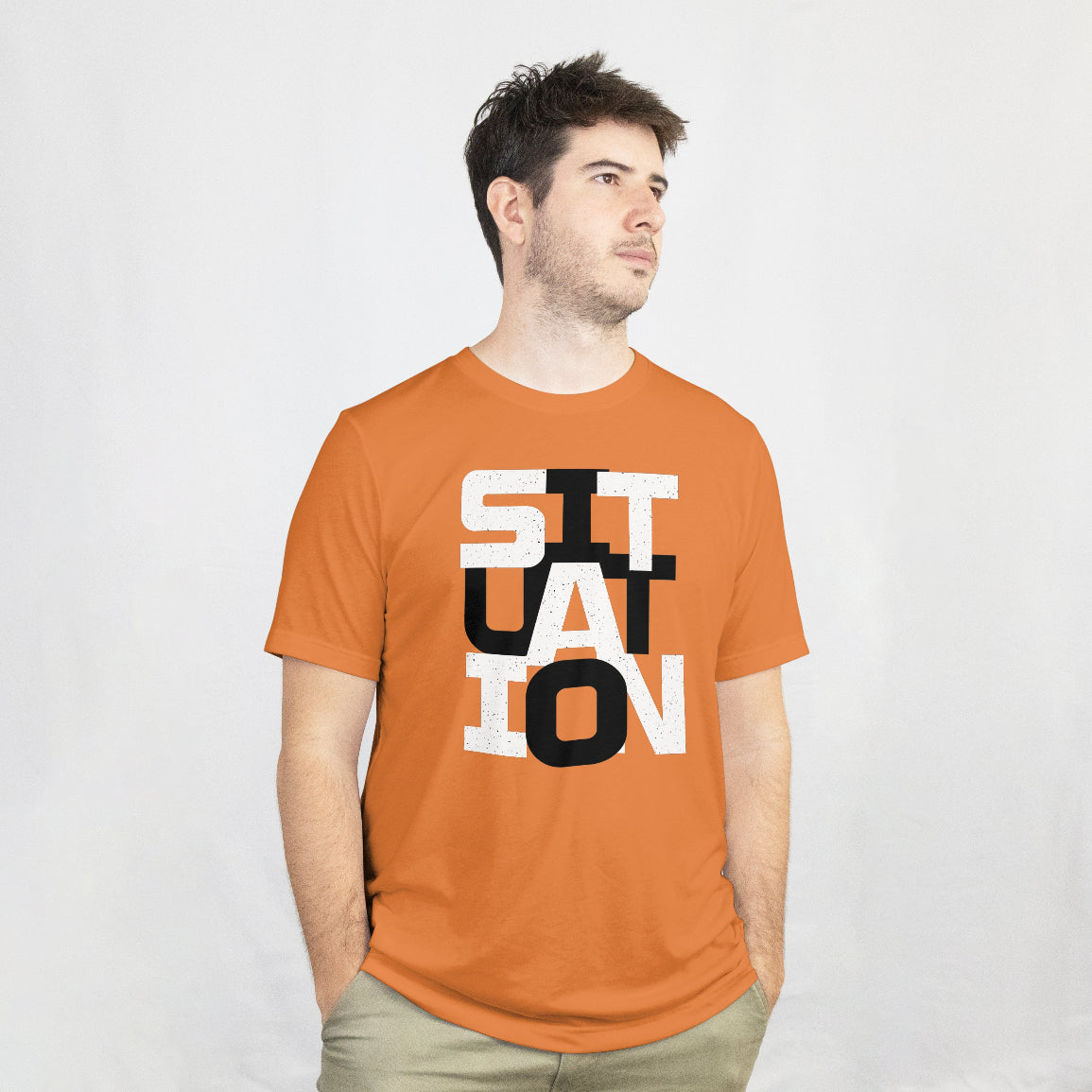 Man wearing an orange t-shirt with 'SITUATION' printed on it against a white background