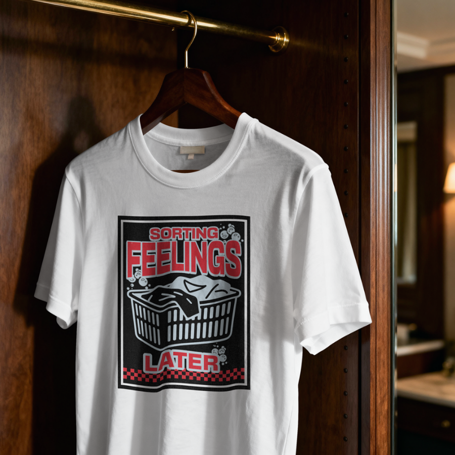 White t-shirt with graphic design hanging on a wooden door