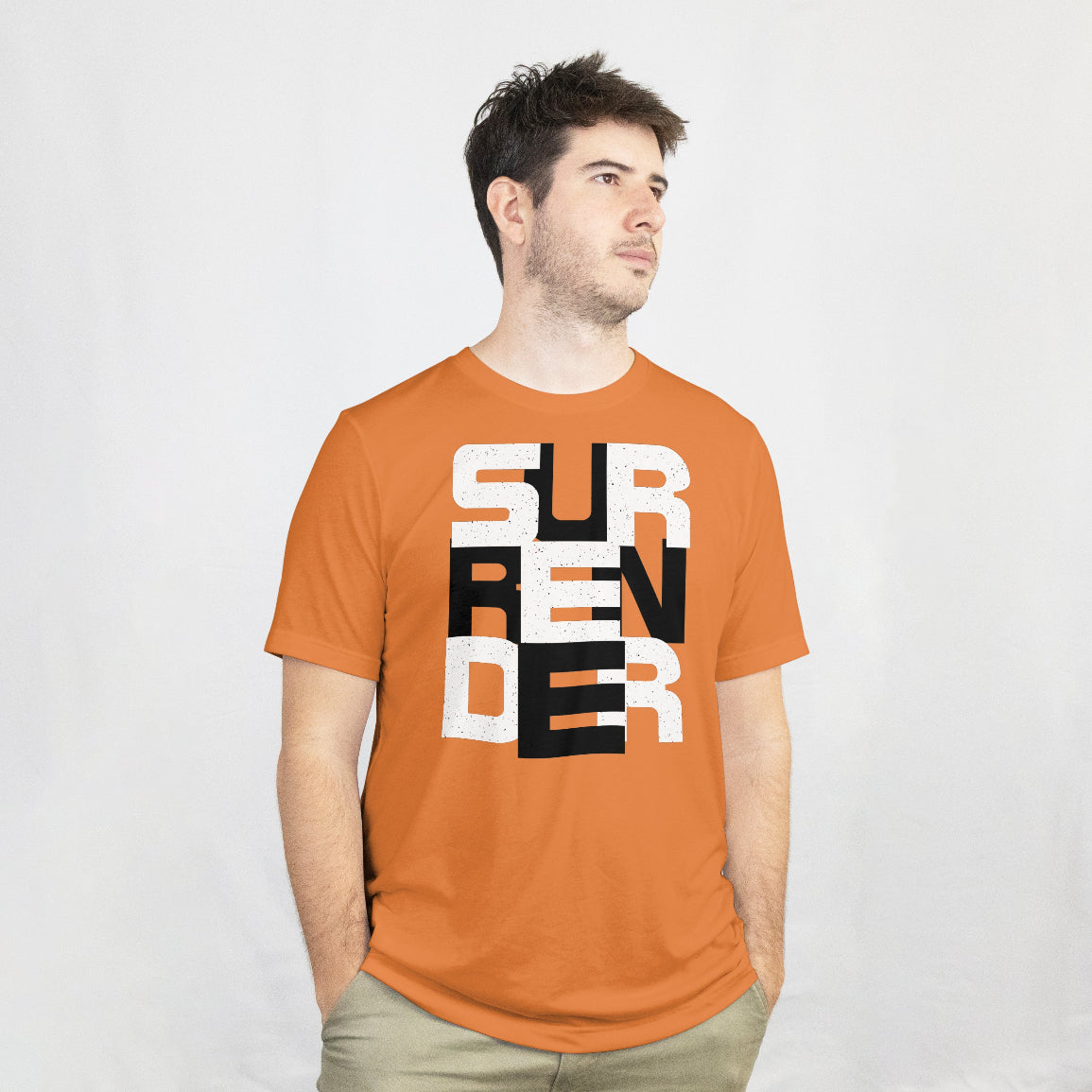 Man wearing an orange t-shirt with 'SURRENDER' printed on it against a white background
