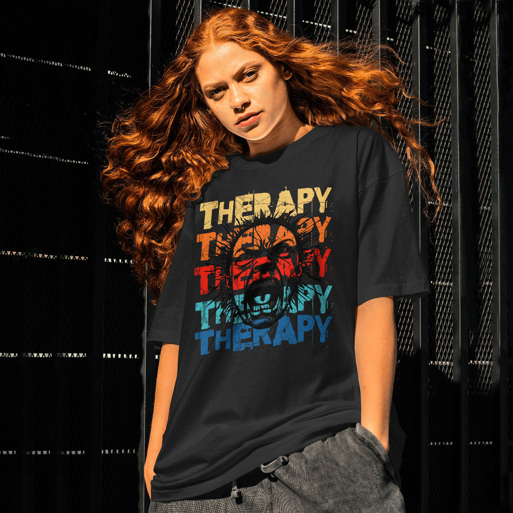 Young lady wearing a black t-shirt with 'Therapy' printed in colorful letters against a dark background.