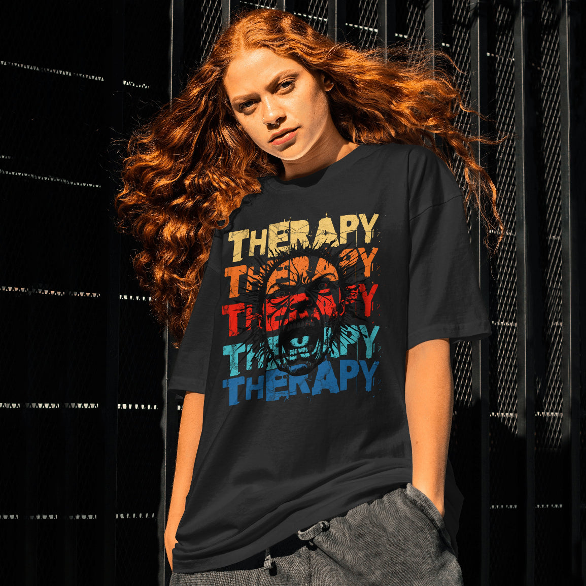 Young lady wearing a black t-shirt with 'Therapy' printed in colorful letters against a dark background.