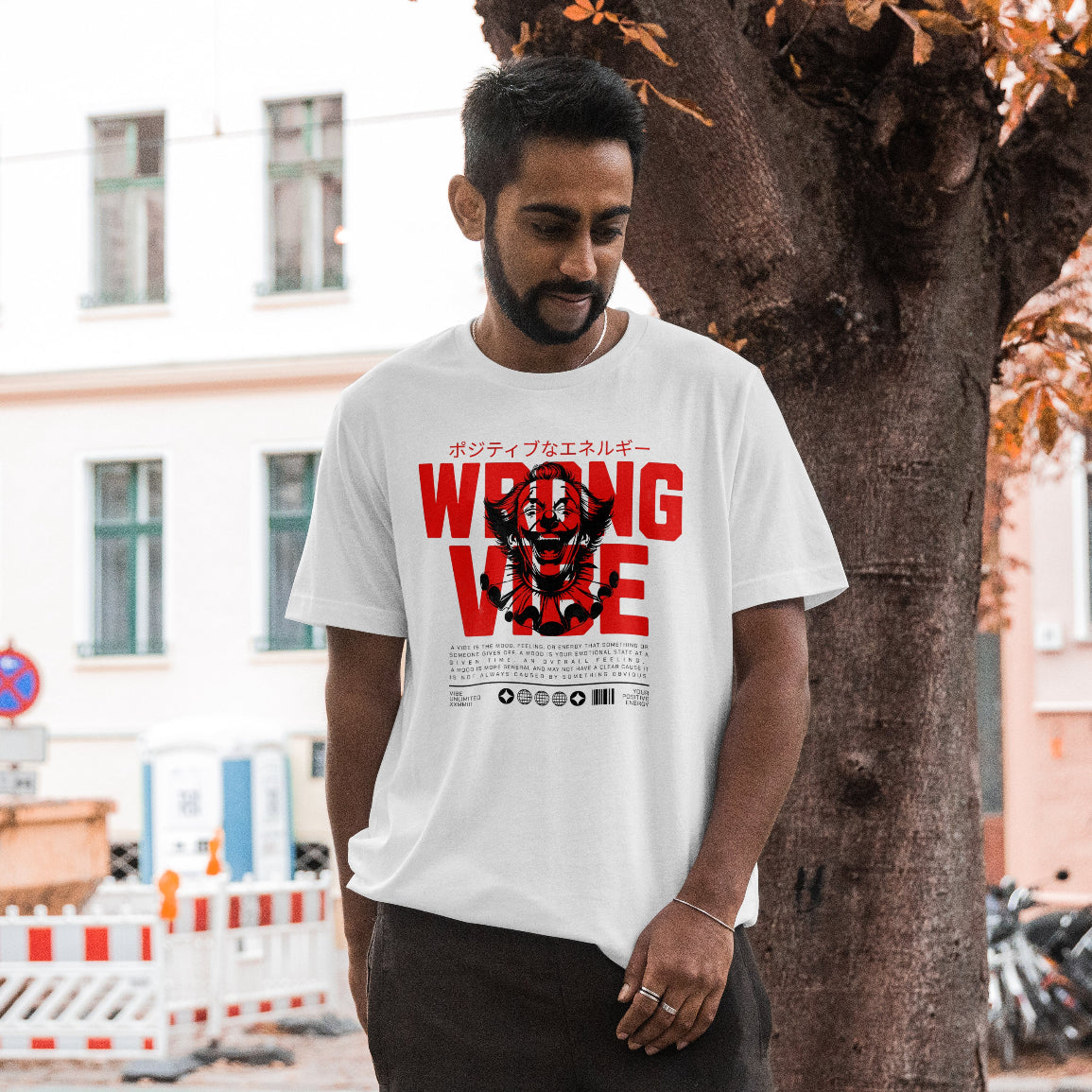Man wearing a white t-shirt with red and black text that reads wrong vibe in an urban setting