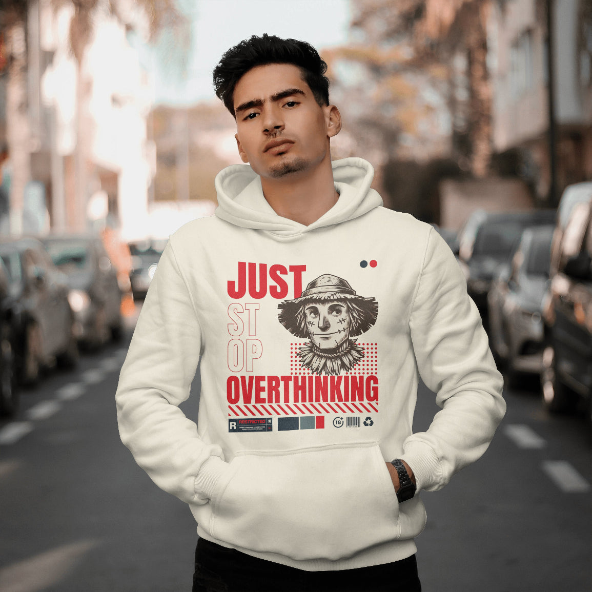 Man wearing a white hoodie with a graphic design and text on a city street.