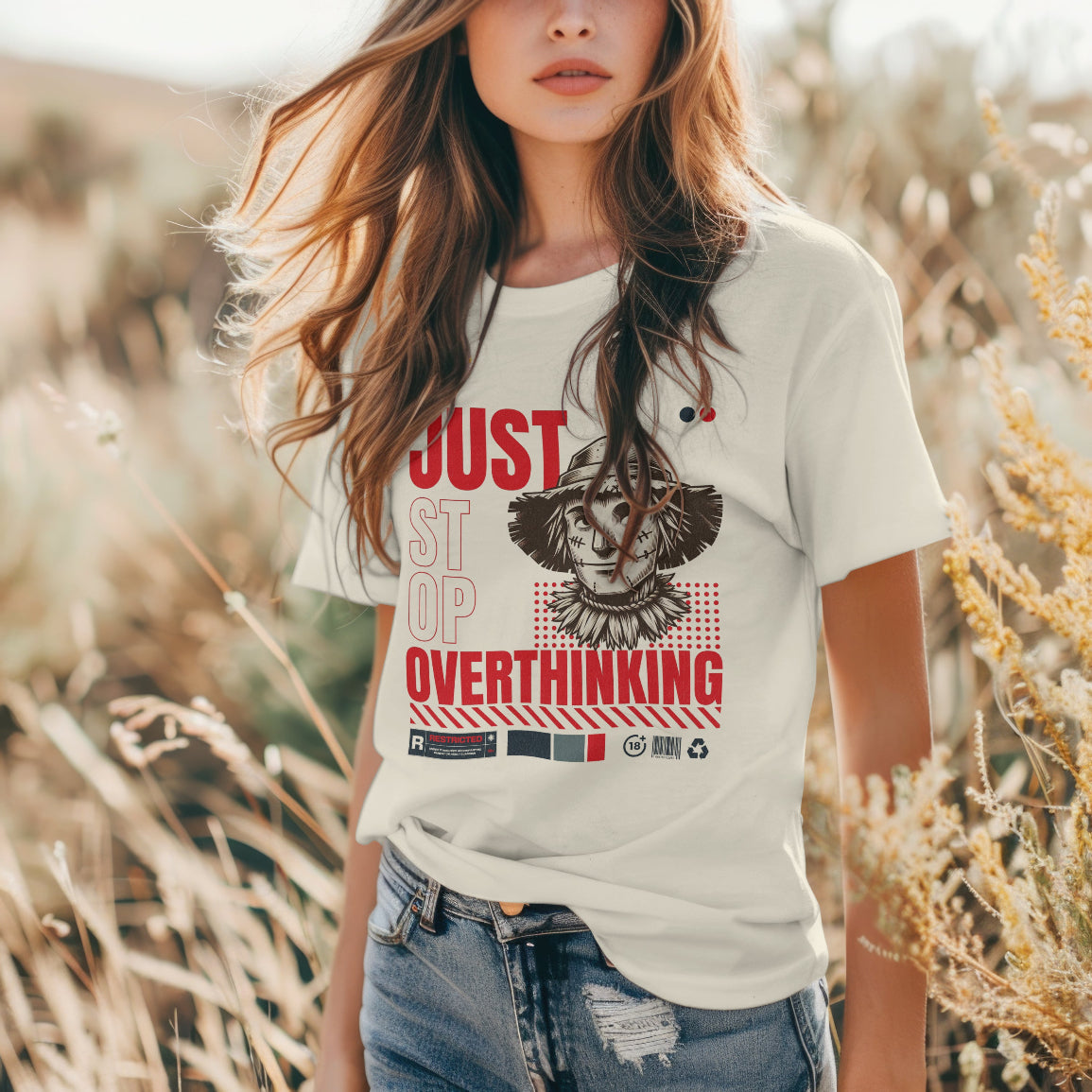 Woman wearing a t-shirt with a graphic and text that reads "just stop overthinking in a natural setting