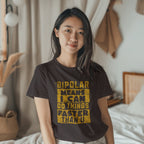 Person wearing a t-shirt with a humorous mental health bipolar quote in a casual indoor setting