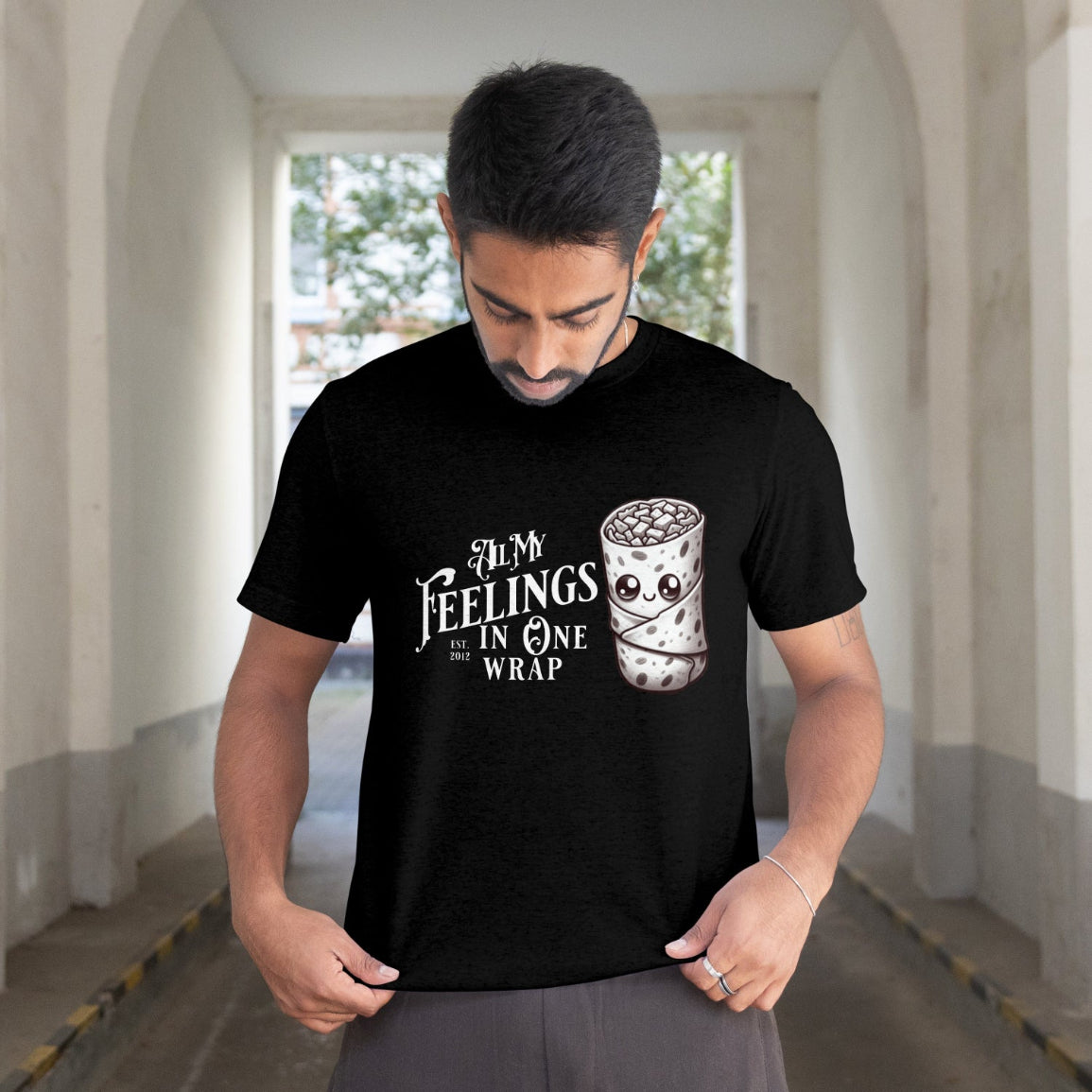 Man wearing a black t-shirt with a graphic design and text in an outdoor setting
