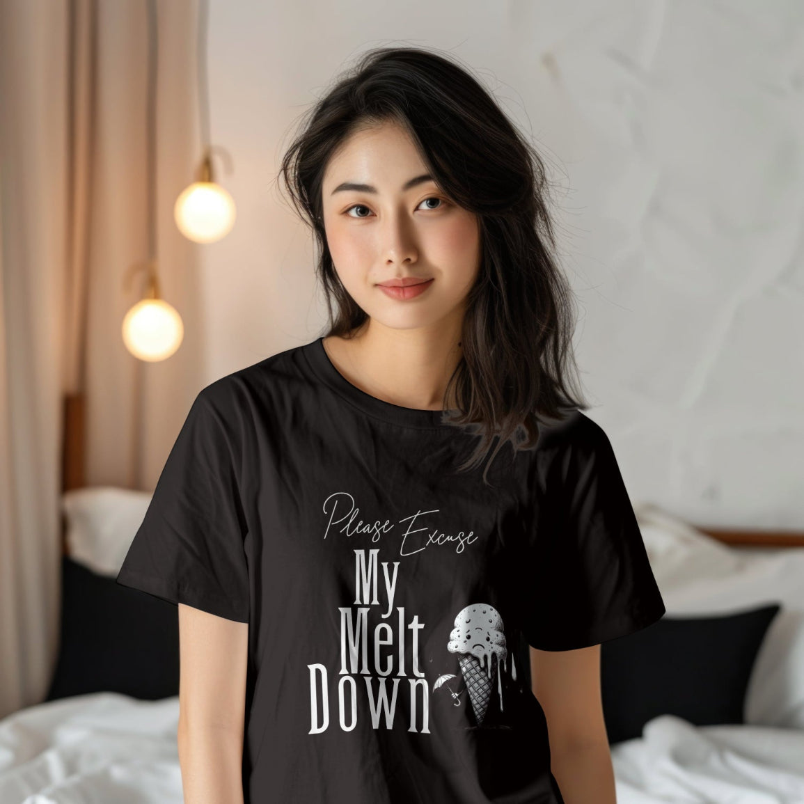 Woman wearing a black t-shirt with text and ice cream graphic in a bedroom setting