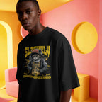 young dark skinned male wearing a black unisex t-shirt with a cat graphic of slightly unsupervised.