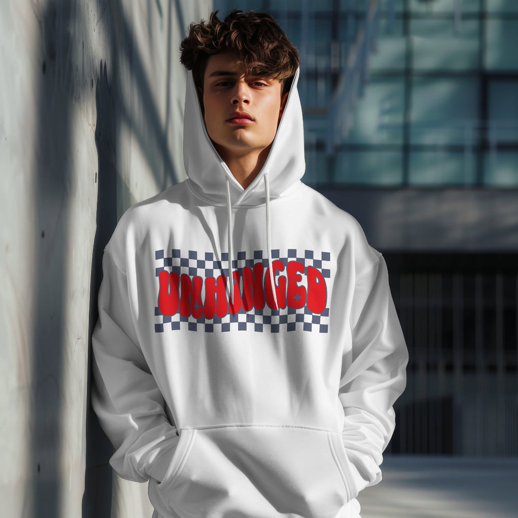 Person wearing a white hoodie with 'UNHINGED' text design, standing against a wall.